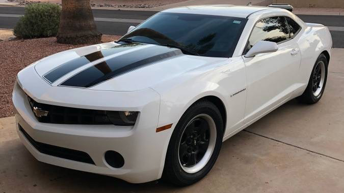 A white Chevy Camaro with black stripes.