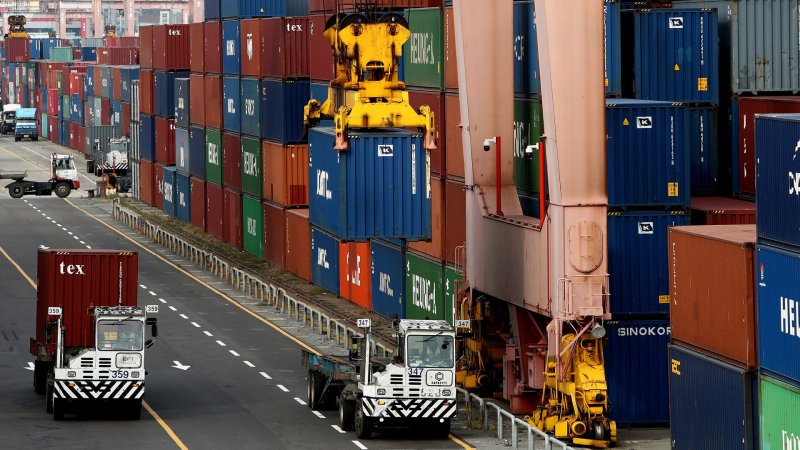 Shipping containers being stacked portside in Busan, Korea.