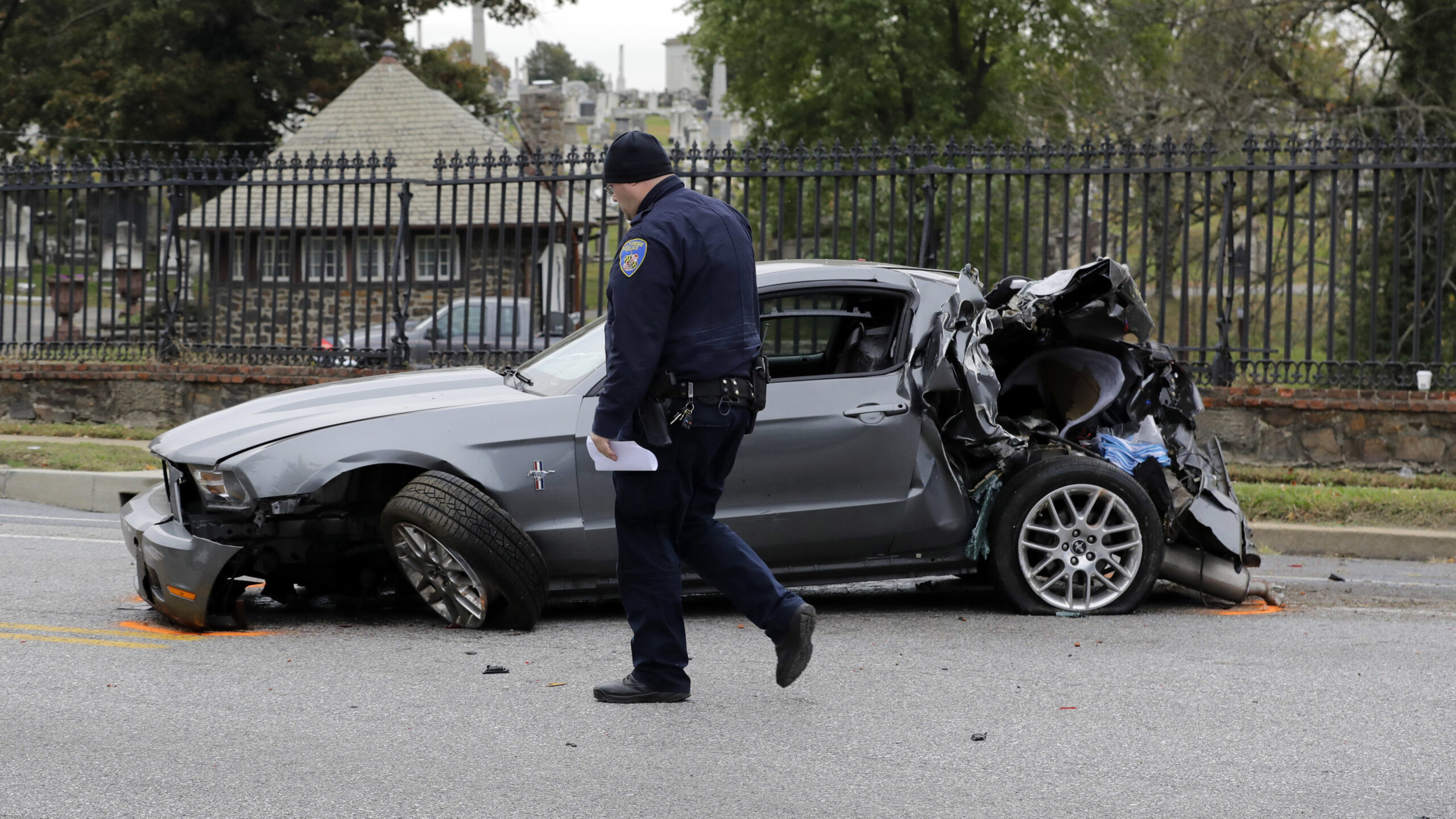 An officer walks past a car involved in a fatal crash