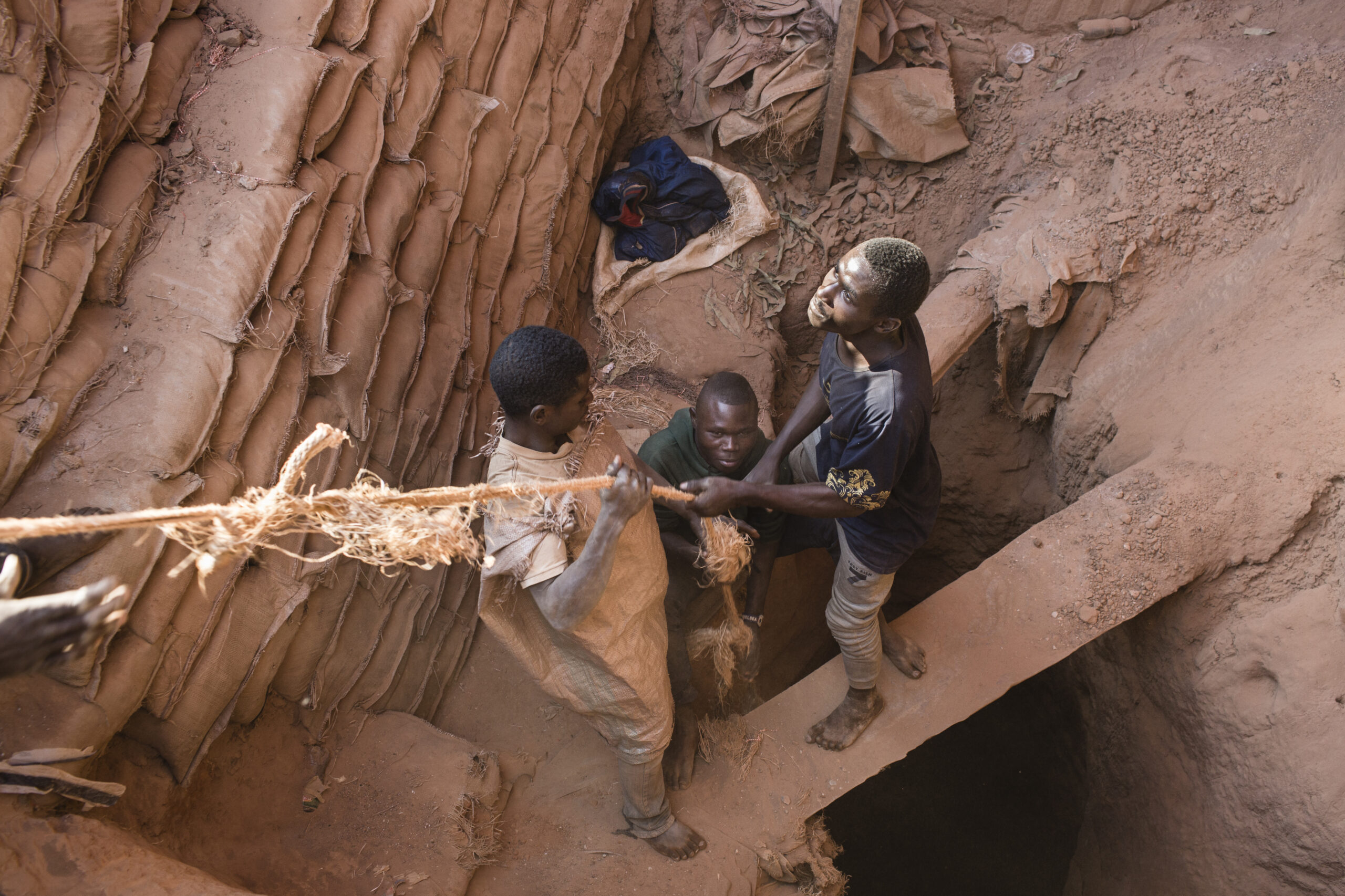 Miners pull up a bag of cobalt their colleague is digging underground inside the CDM (Congo DongFang Mining) Kasulo mine.