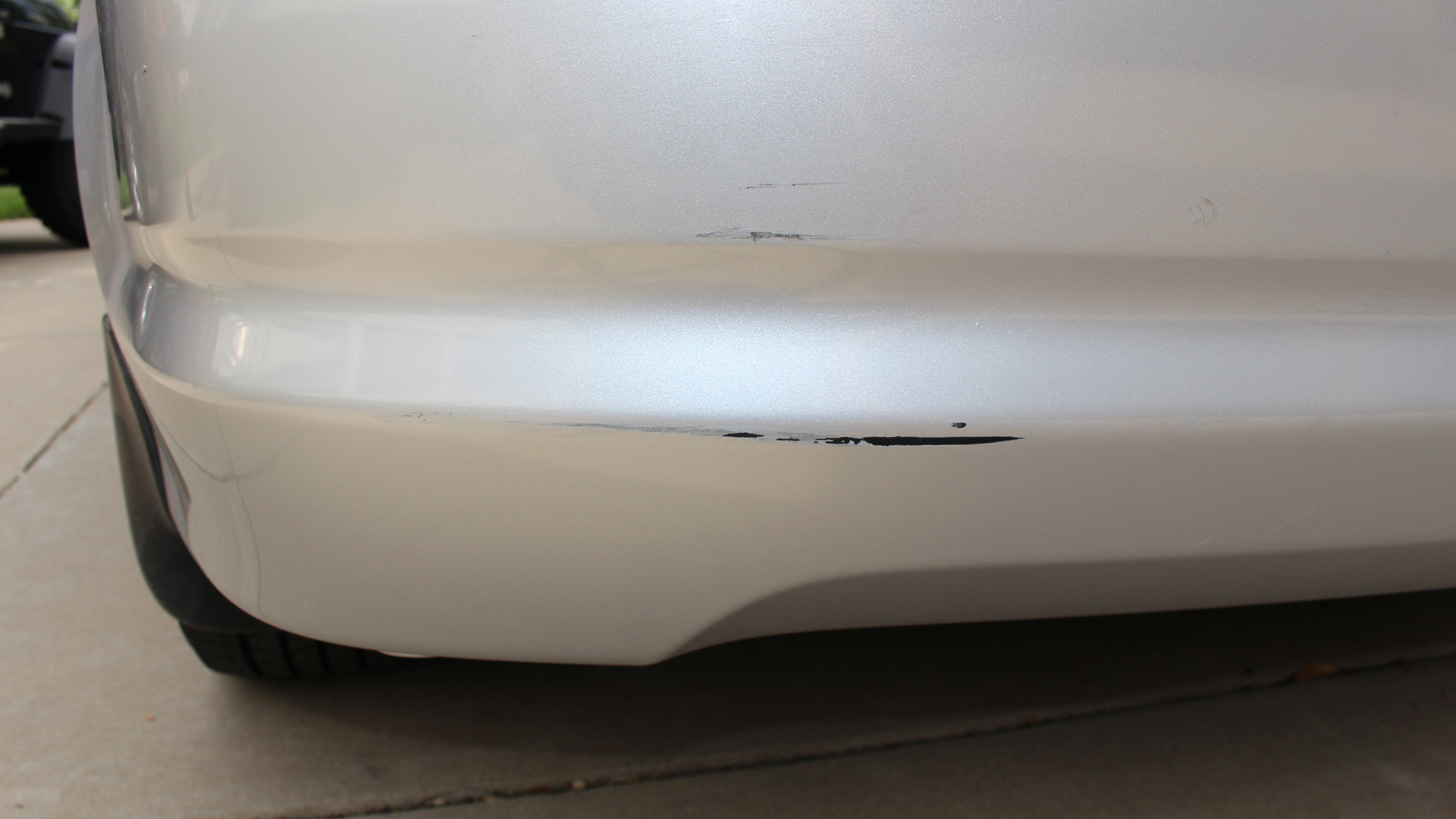 A silver Acura RSX rear bumper with a scratch.