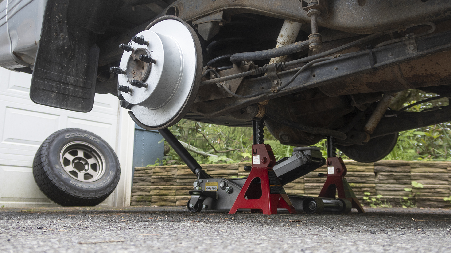 An SUV being supported by jack stands under the rear axle.
