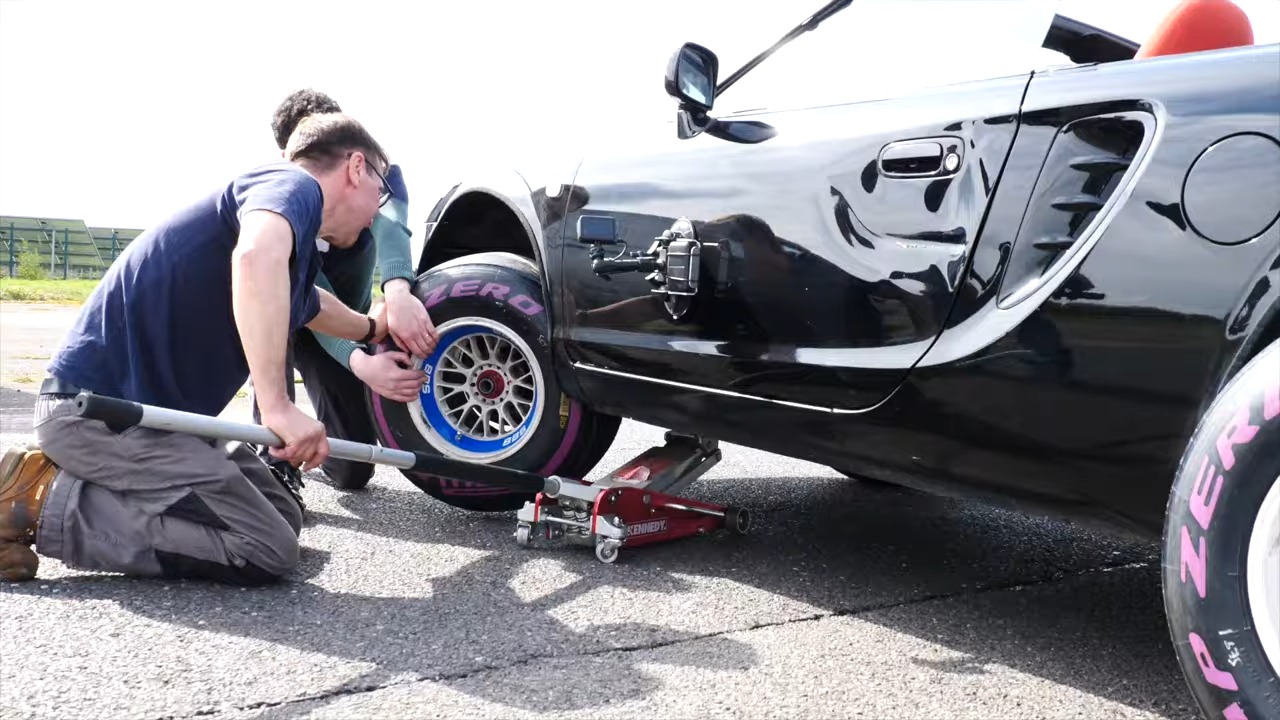 A Toyota MR2 on jacks with an F1 tire fitted.