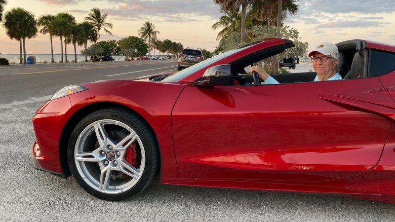 Red Corvette with man smiling in the driver's seat