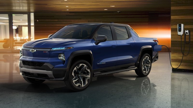 A blue Chevy Silverado truck charging at a wall socket