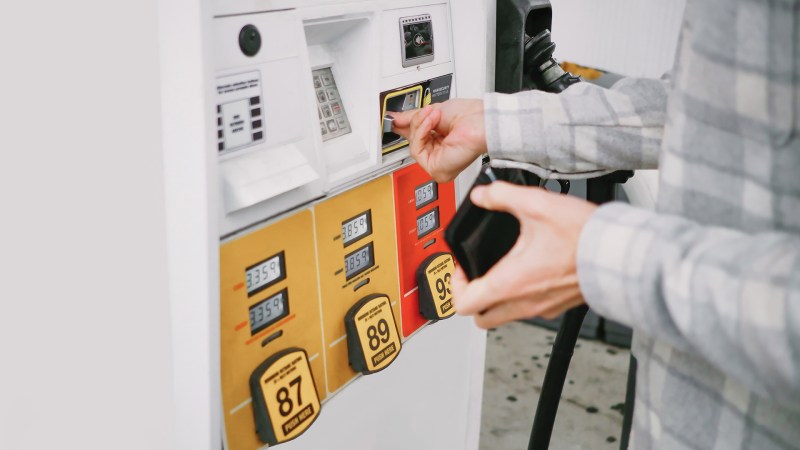 A person using a credit card at the gas pump.