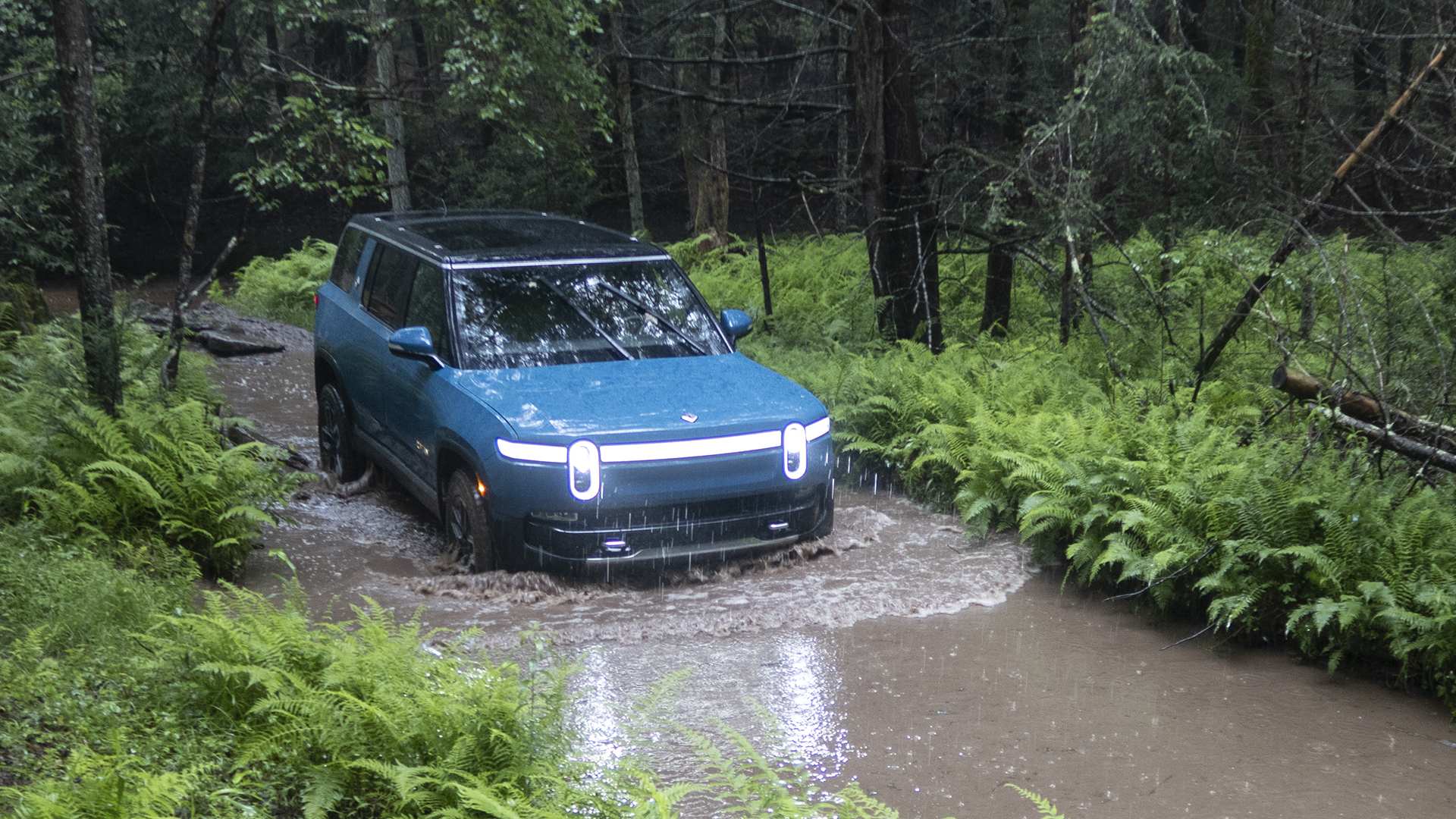 Rivian R1S fording water.