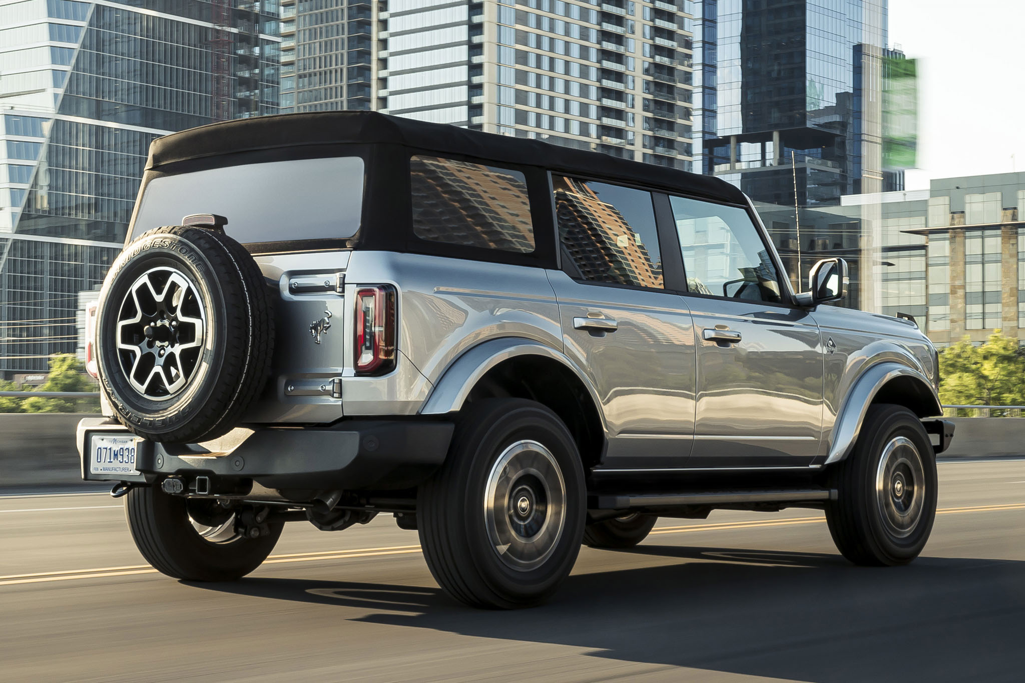 A rear 3/4 view of a Ford Bronco driving on the highway.