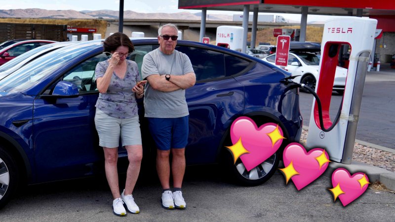 A couple stand by a Tesla Supercharger, with hearts overlaid on top.