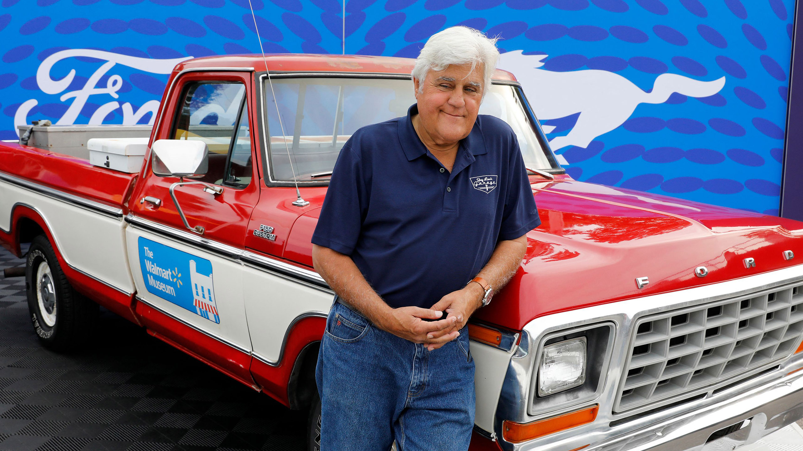 Jay Leno poses in front of a Ford pickup truck