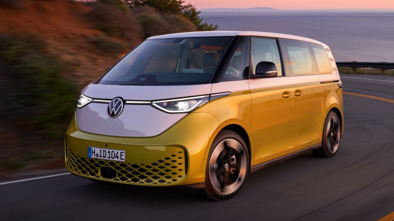 VW ID Buzz (European model) in white-on-yellow against an oceanic sunset