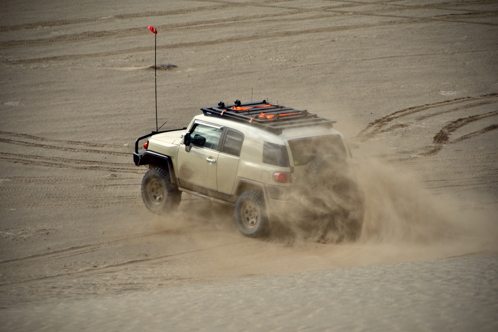 A Toyota FJ Cruiser kicking up sand