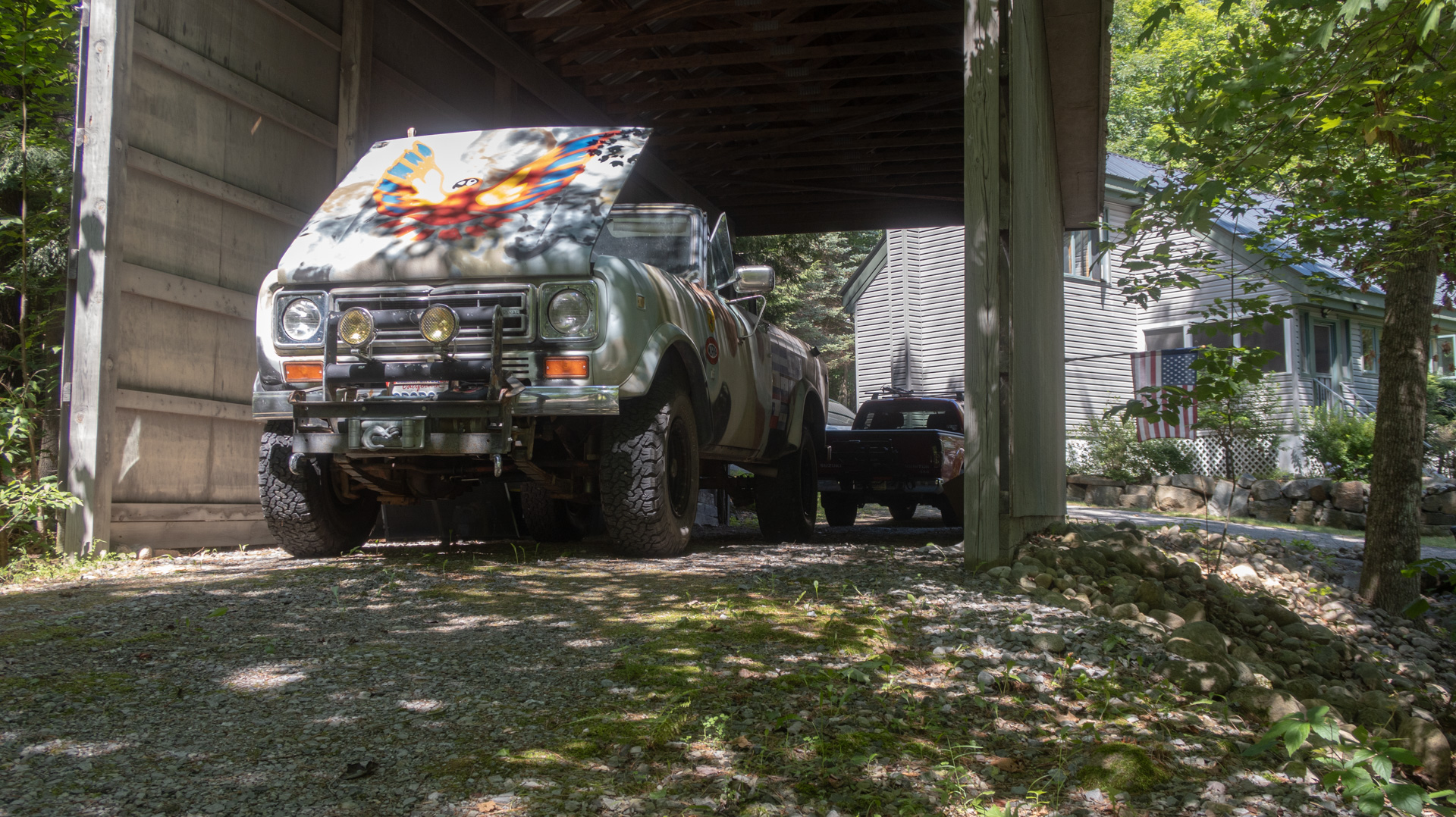 Square 1970s truck parked under a large roof.