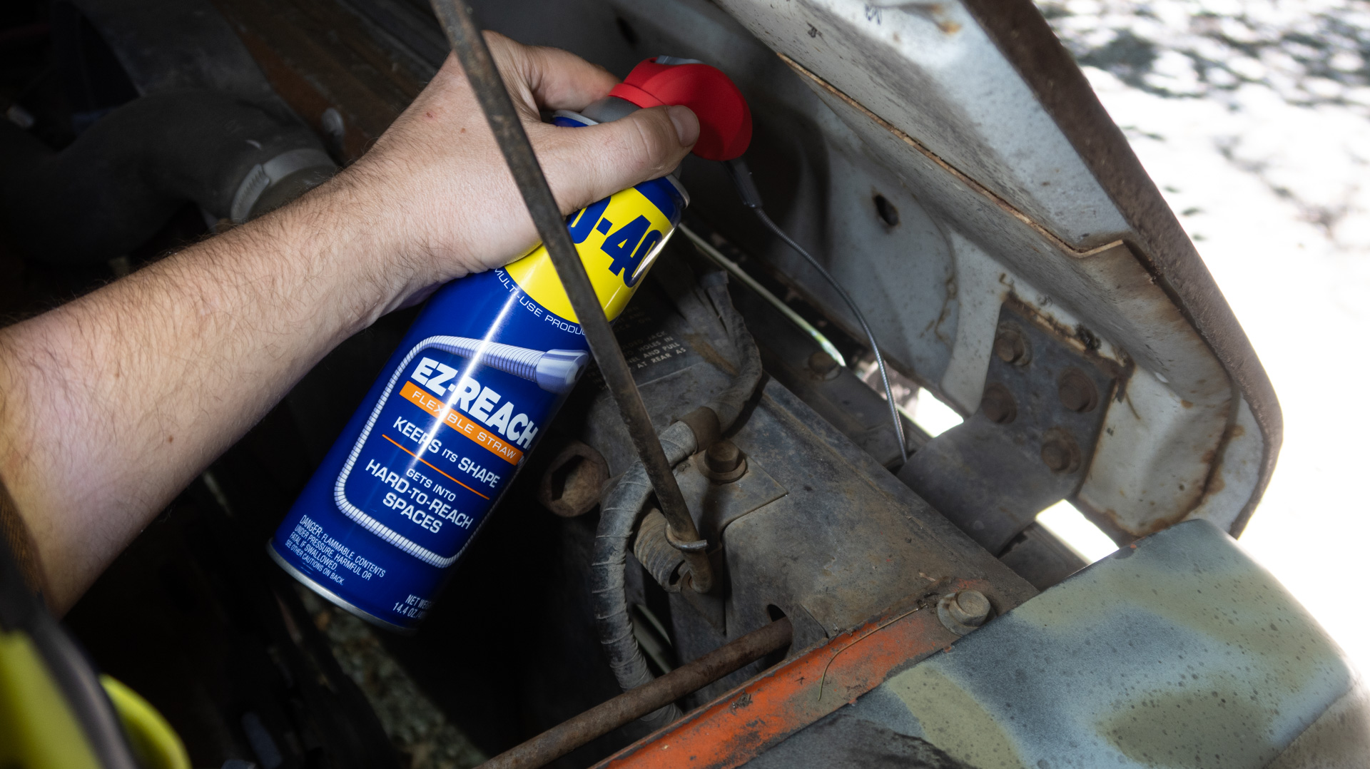 WD-40 EZ-REACH lubricating a hood hinge.