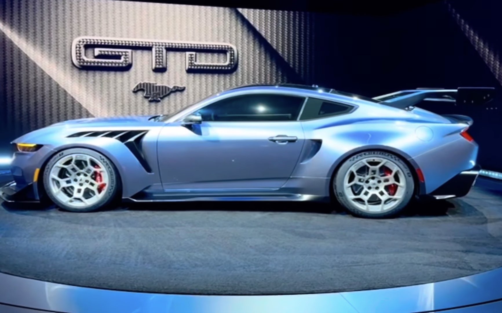 Alleged Ford Mustang GTD, a Mustang-shaped coupe seen from the side. It has a heavily vented front fender, complex five-spoke wheels, an intake on its rear fender, and a large rear wing mounted to its fastback roofline.