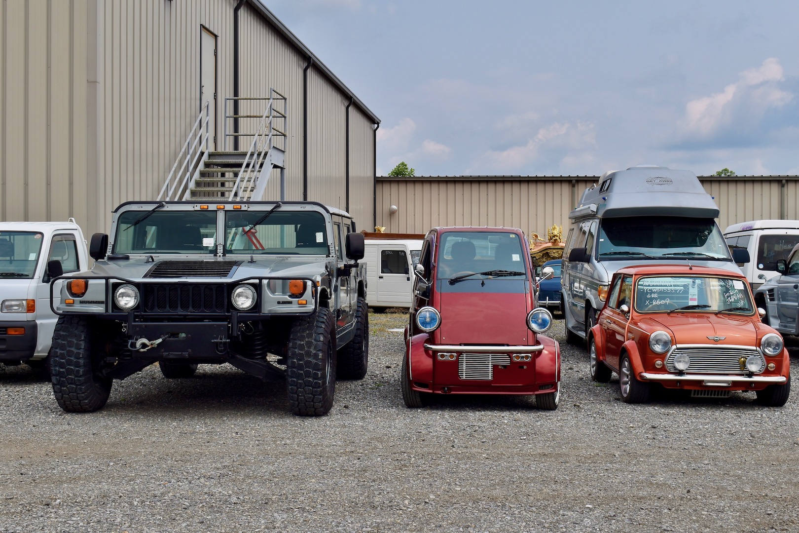 1996 Daihatsu Midget II between a Hummer H1 and Mini 