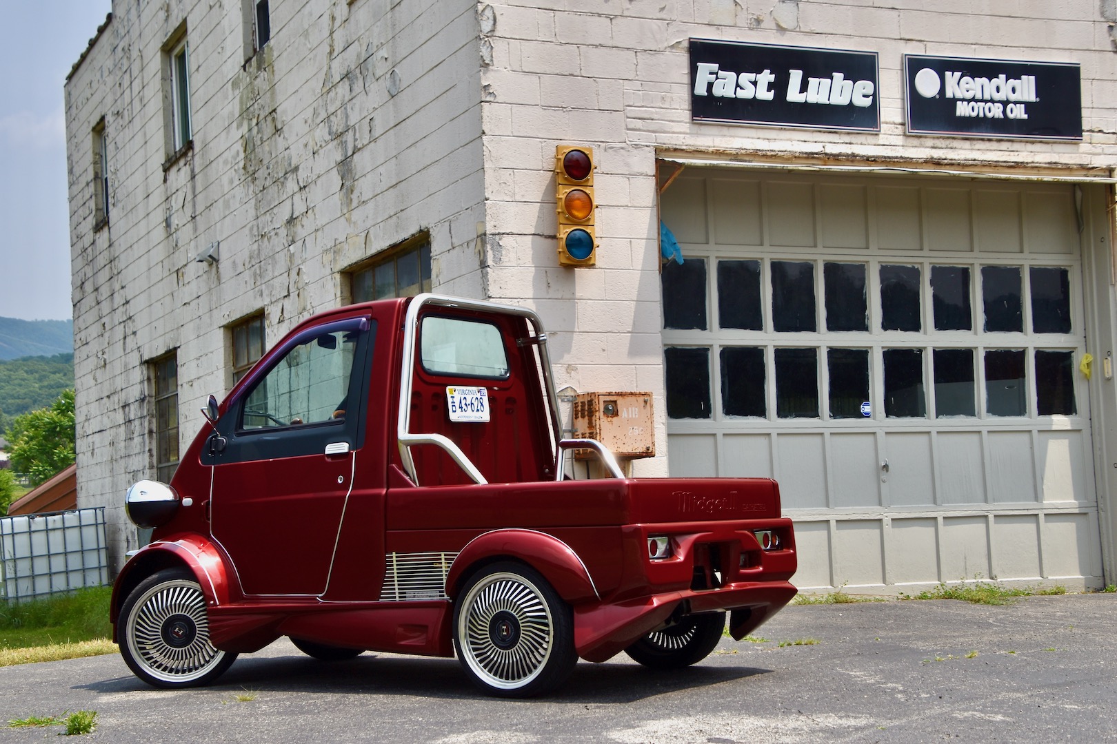 1996 Daihatsu Midget II in front of a former oil change shop