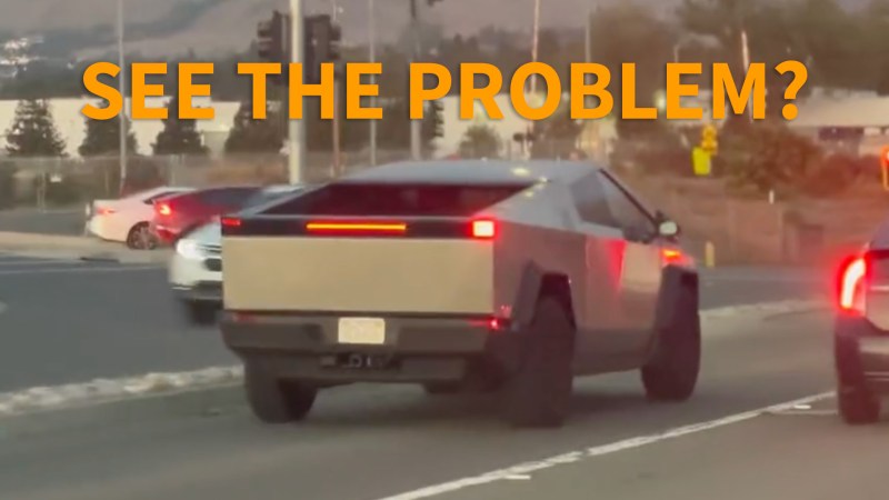 A Tesla Cybertruck viewed from the rear, with its brake lights active