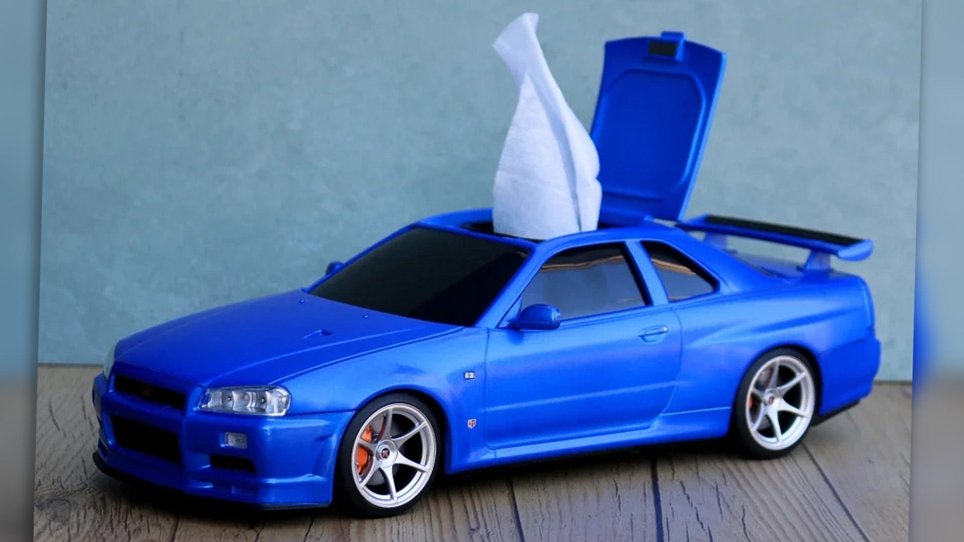 A blue Nissan Skyline GT-R model (R34) with a hatch in its roof to dispense tissues