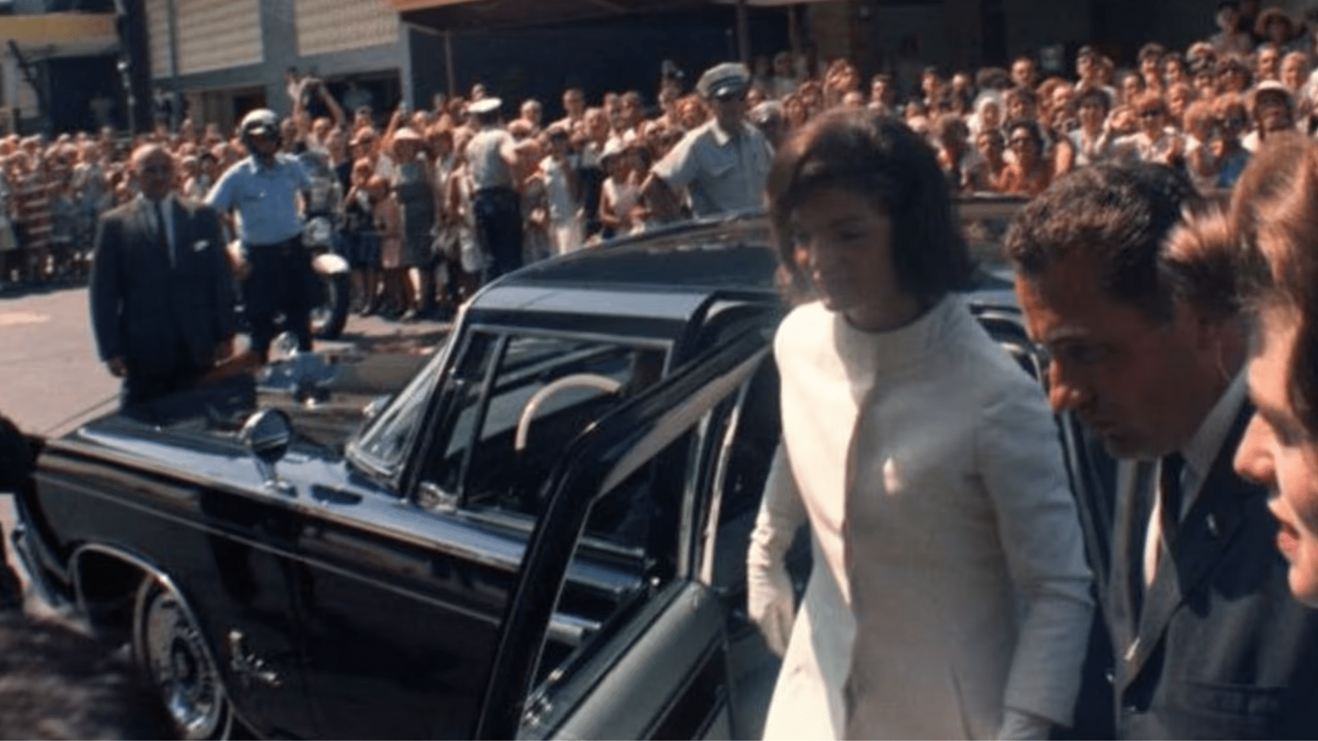 woman in front of a black car