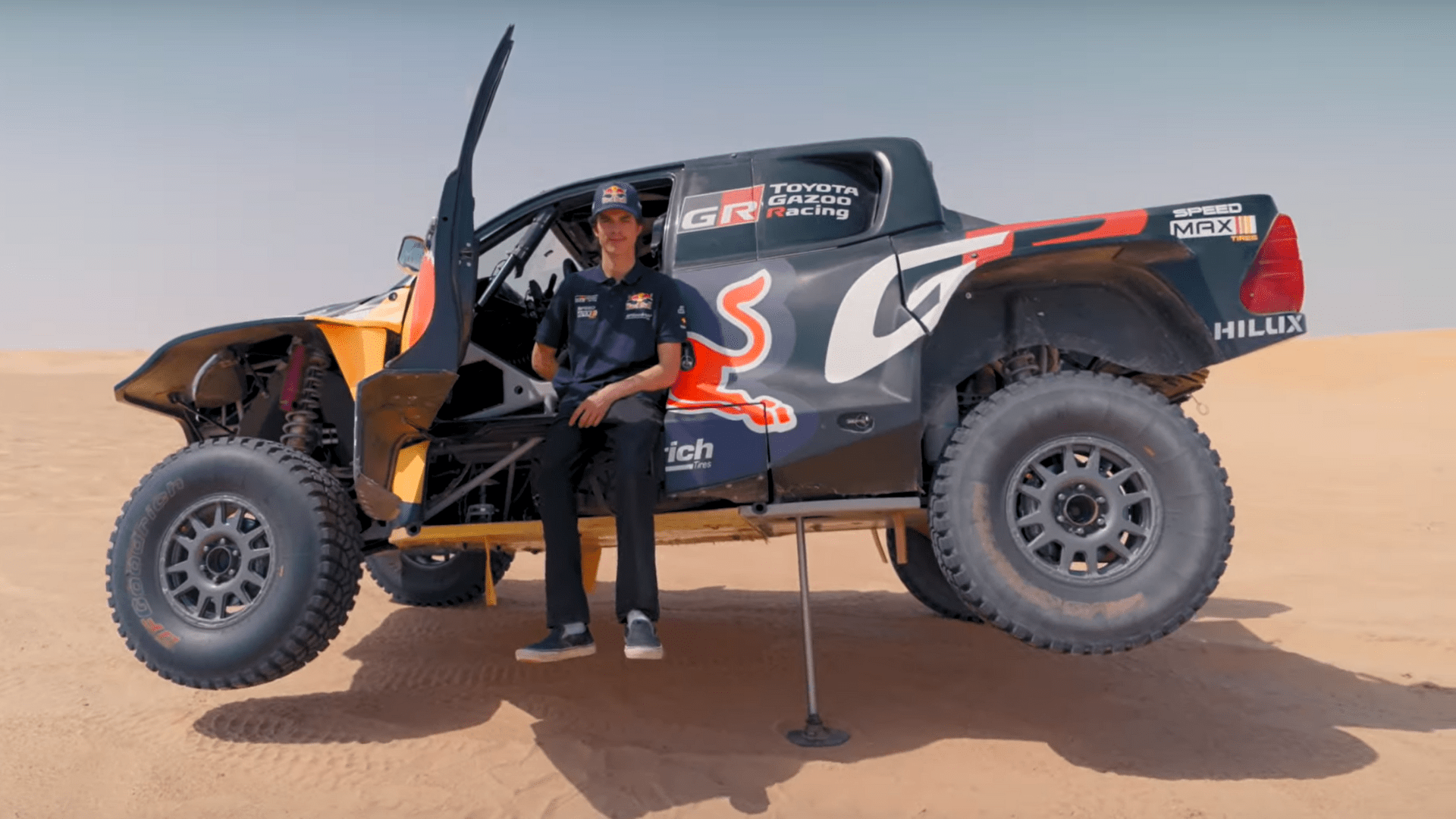 man sitting inside a jacked-up race truck