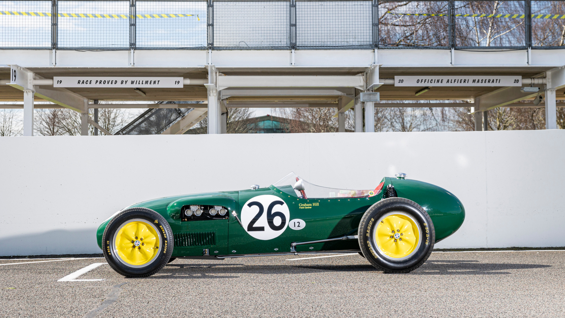 side view green racecar on a track