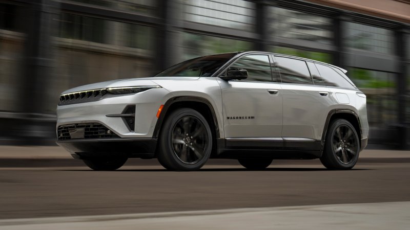 Silver Jeep Wagoneer S electric SUV speeding through city.