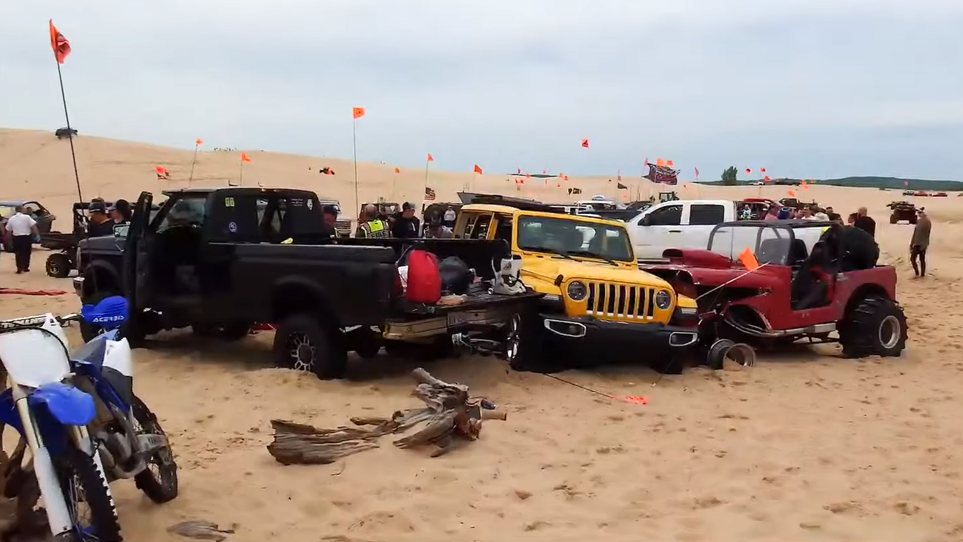 A screenshot of a YouTube video from WOOD TV8 showing the aftermath of a crash in which a drag racing Jeep CJ struck a family's yellow Jeep Wrangler, that resulted in the death of a 33-year-old spectator.