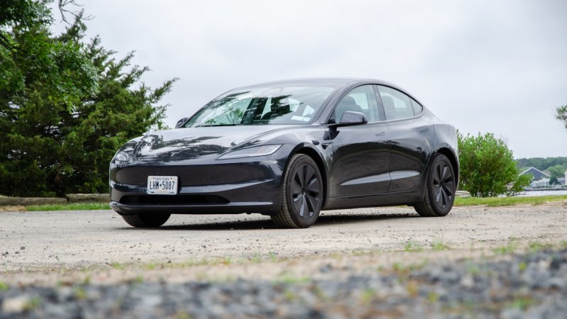 dark grey 2024 tesla model 3 parked on a dirt lot