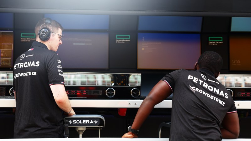 BUDAPEST, HUNGARY - JULY 19: A Mercedes team member, whose shirt bears the logo of team sponsor Crowdstrike, looks on as Windows error screens are seen on their pitwall prior to practice ahead of the F1 Grand Prix of Hungary at Hungaroring on July 19, 2024 in Budapest, Hungary. Businesses, travel companies and individual Microsoft users across the globe were among those affected by a tech outage today.(Photo by Bryn Lennon/Getty Images)