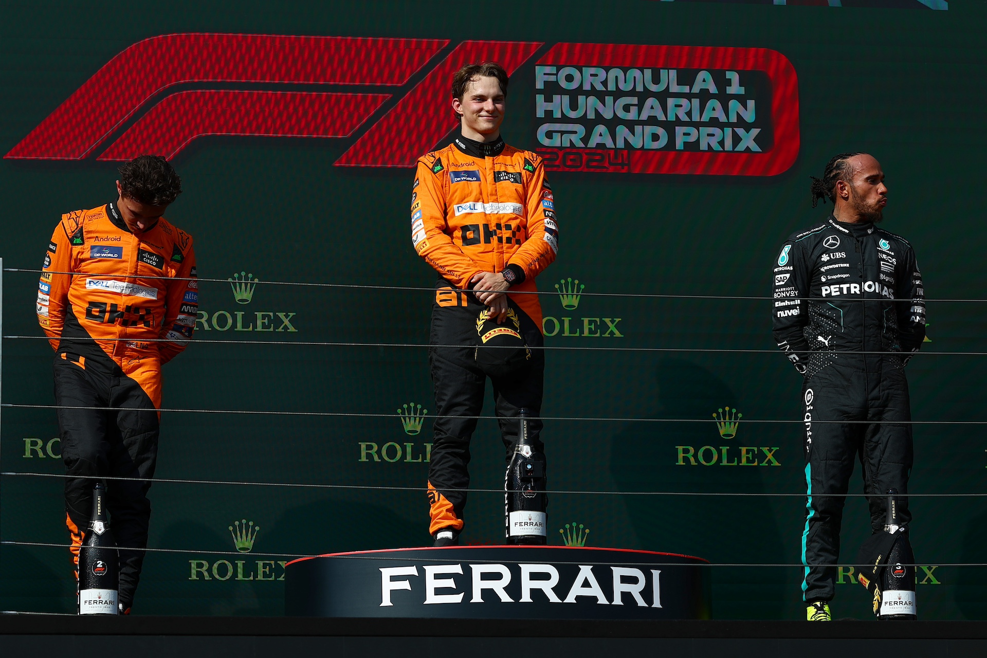 BUDAPEST, HUNGARY - JULY 21:Race winner Oscar Piastri of Australia and McLaren, Second placed Lando Norris of Great Britain and McLaren and Third placed Lewis Hamilton of Great Britain and Mercedes stand on the podium during the F1 Grand Prix of Hungary at Hungaroring on July 21, 2024 in Budapest, Hungary. (Photo by Joe Portlock - Formula 1/Formula 1 via Getty Images)