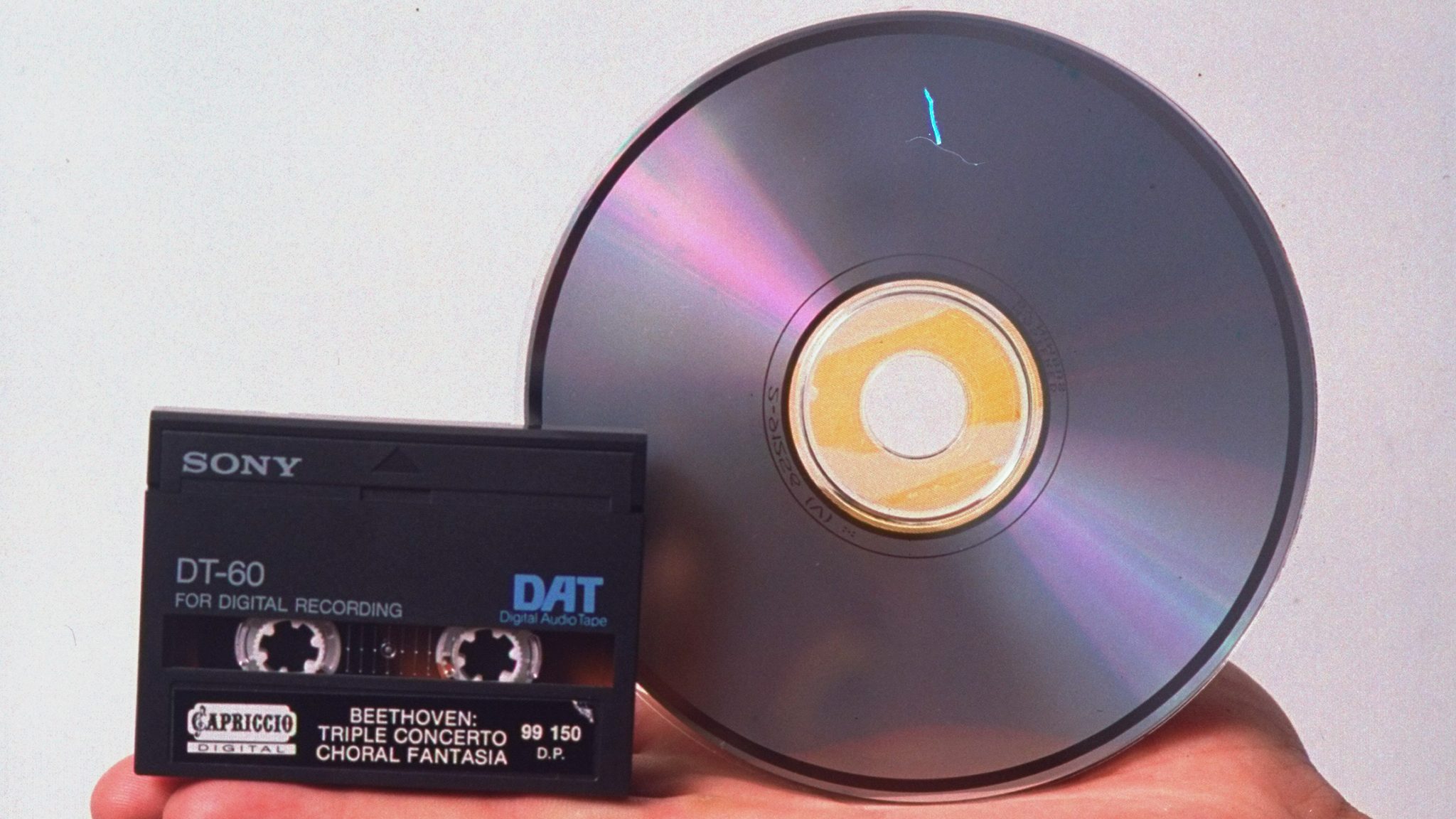 Hand holding compact disc and newest item in consumer sound recording technology, a digital audio tape (DAT). (THIS DAT MADE BY SONY) (Photo by James Keyser/Getty Images)