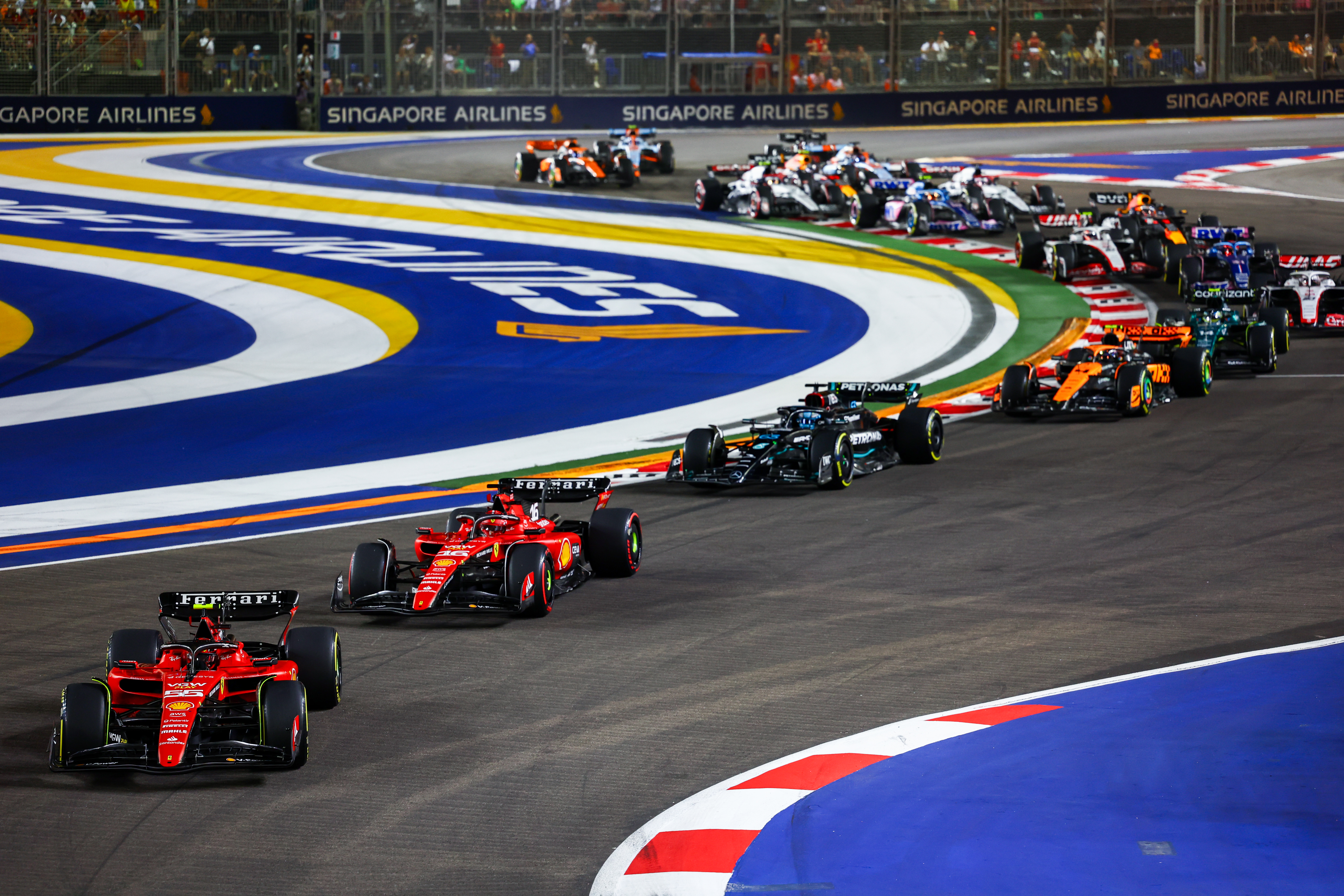 SINGAPORE, SINGAPORE - SEPTEMBER 17: Carlos Sainz of Spain driving (55) the Ferrari SF-23 leads Charles Leclerc of Monaco driving the (16) Ferrari SF-23 and the rest of the field at the start during the F1 Grand Prix of Singapore at Marina Bay Street Circuit on September 17, 2023 in Singapore, Singapore. (Photo by Mark Thompson/Getty Images)