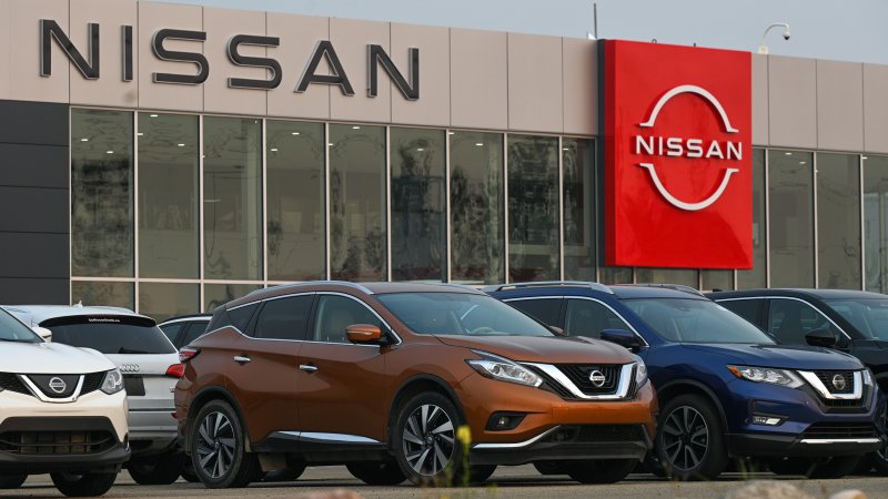 Nissan vehicles outside a Nissan dealership.