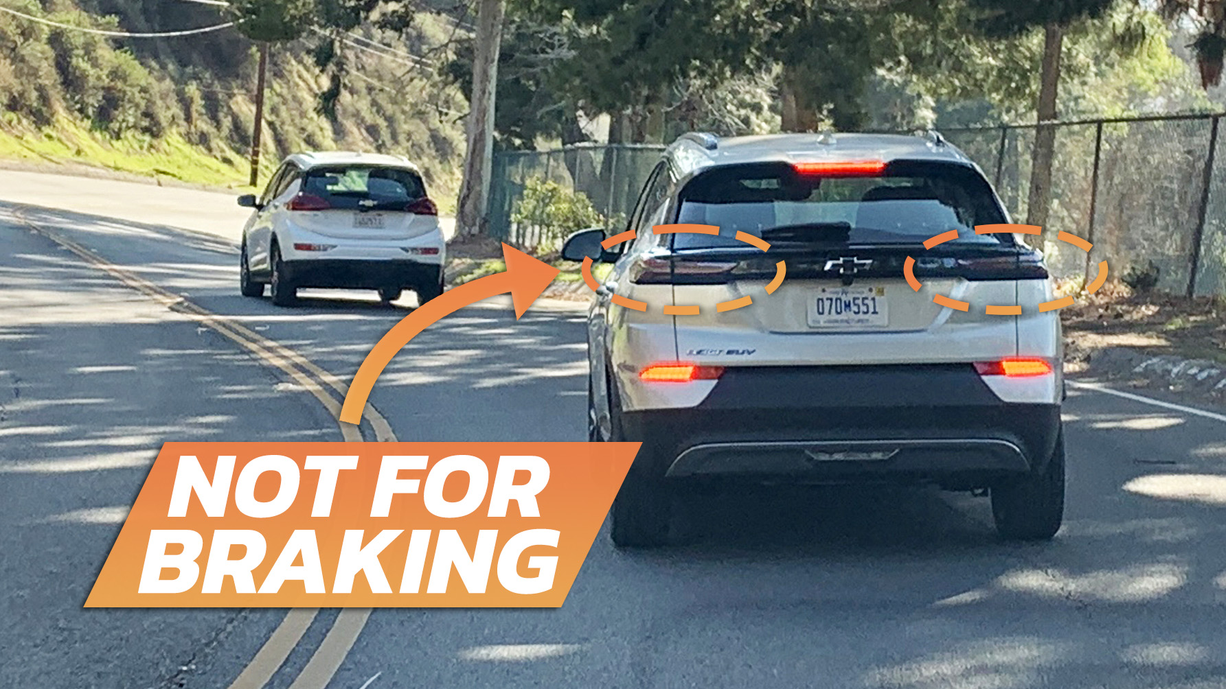 Image of the rear of a 2022-2023 Chevrolet Bolt braking in the daylight, where you can see the upper taillights aren't lit and the actual brake lights are near the bottom of the bumper.