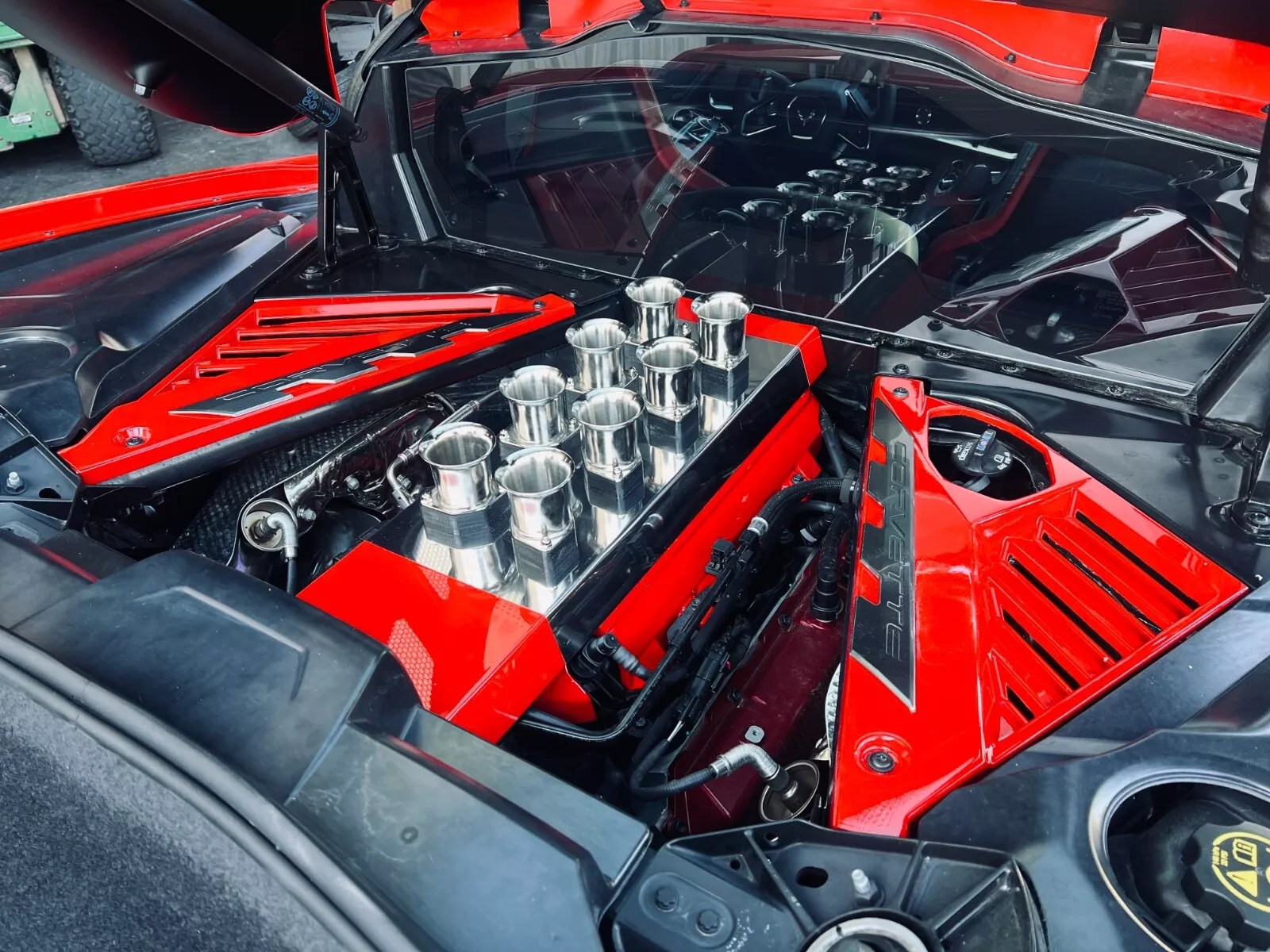 Fake velocity stacks and independent throttle bodies on a C8 Corvette engine cover.