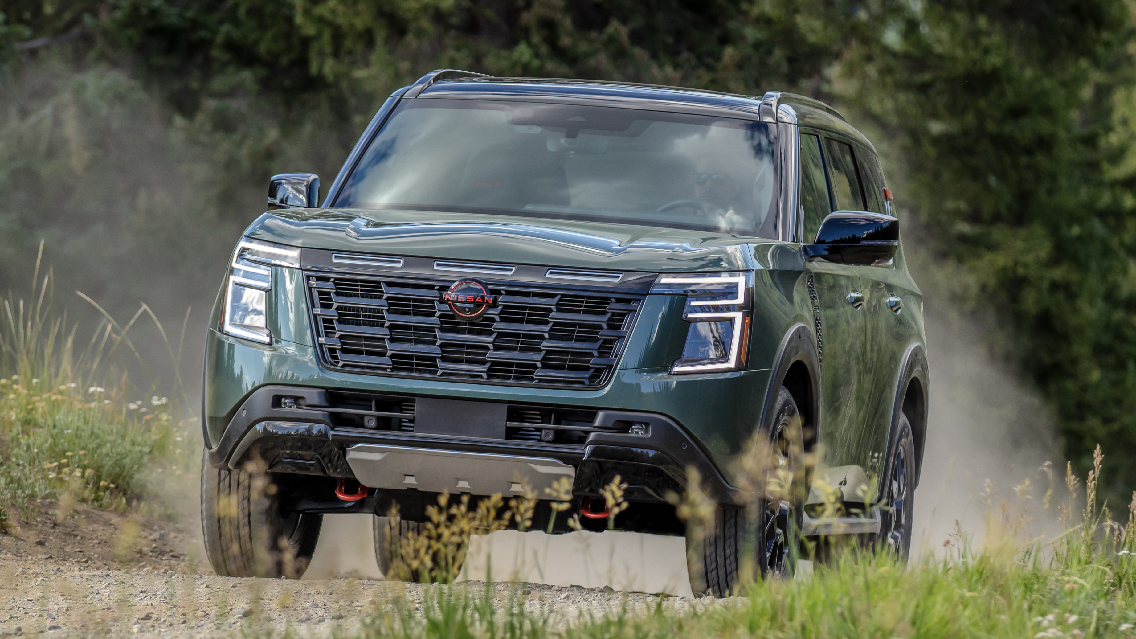 Nissan Armada SUV emerging from a dust cloud.