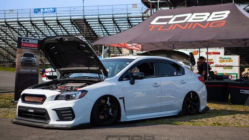 A Subaru WRX in front of a Cobb Tuning tent