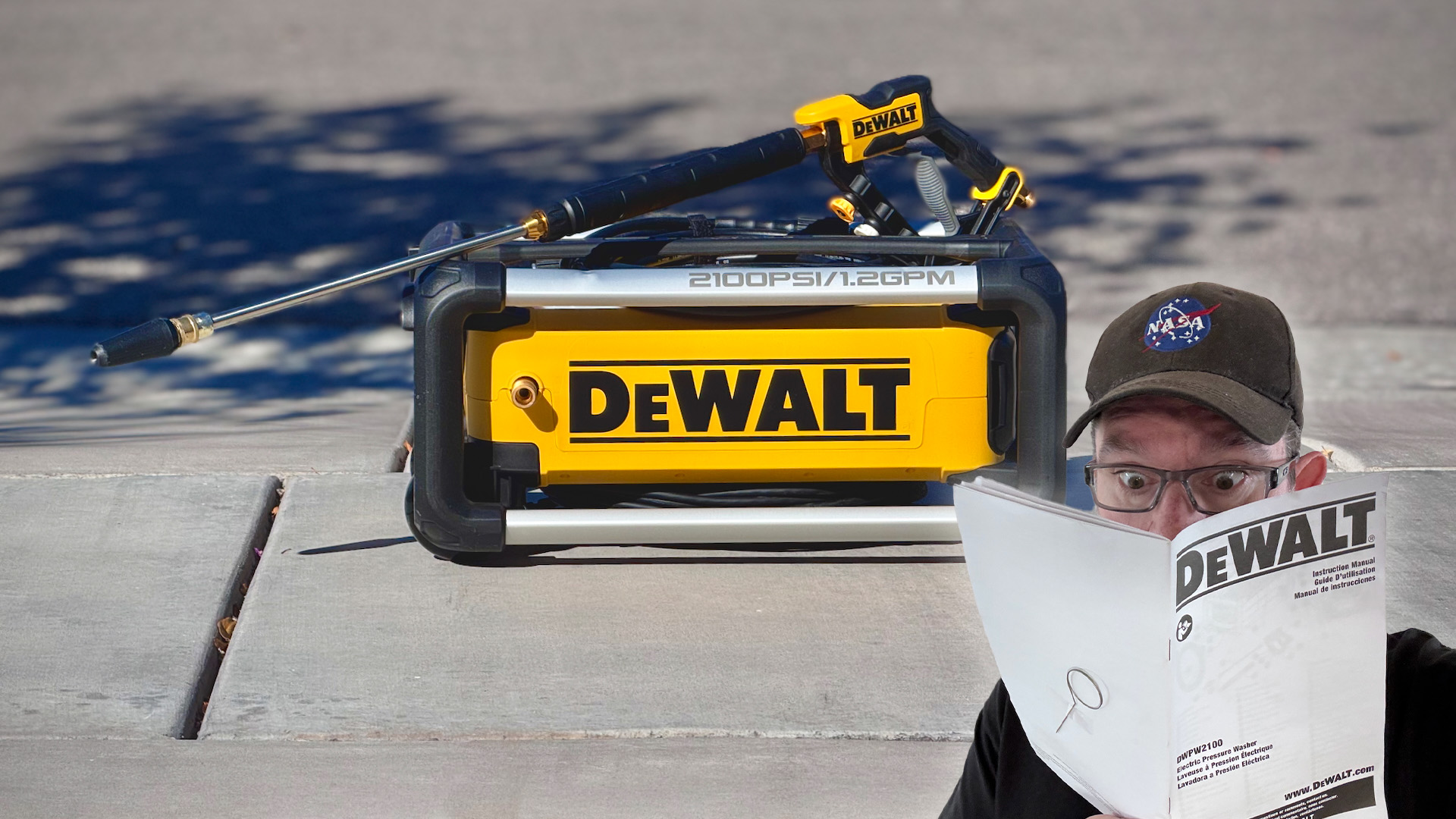 The DeWalt electric pressure washer, accompanied by somebody reading its manual