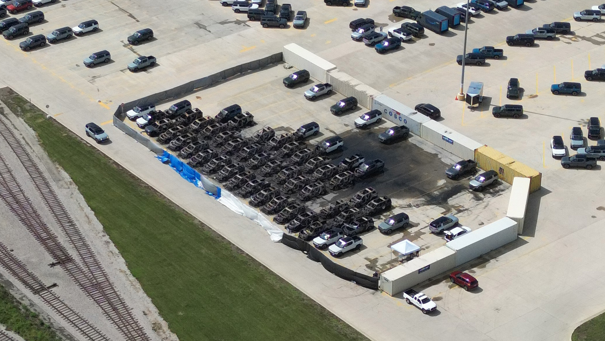 Overhead image of Rivian plant lot containing burned vehicles.