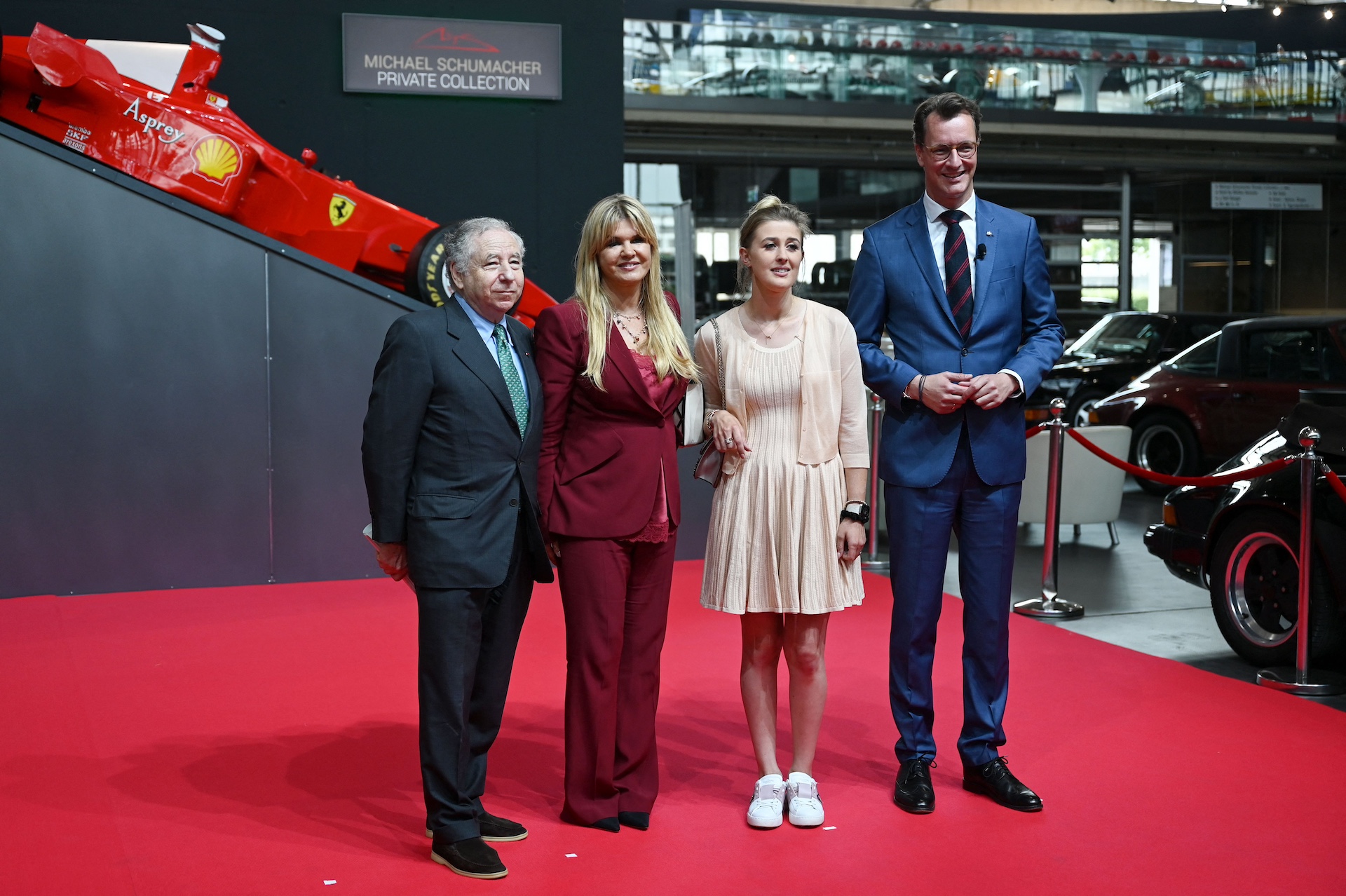 Corinna Schumacher (2ndL), wife of former Formula One champion Michael Schumacher, daughter Gina Schumacher, former FIA president Jean Todt (L) and North Rhine-Westphalia's State Premier Hendrik Wuest pose on the red carpet prior to the presentation of a State Prize to Michael Schumacher at the Motorworld Koeln event location in Cologne, western Germany on July 20, 2022. (Photo by INA FASSBENDER / AFP) (Photo by INA FASSBENDER/AFP via Getty Images)