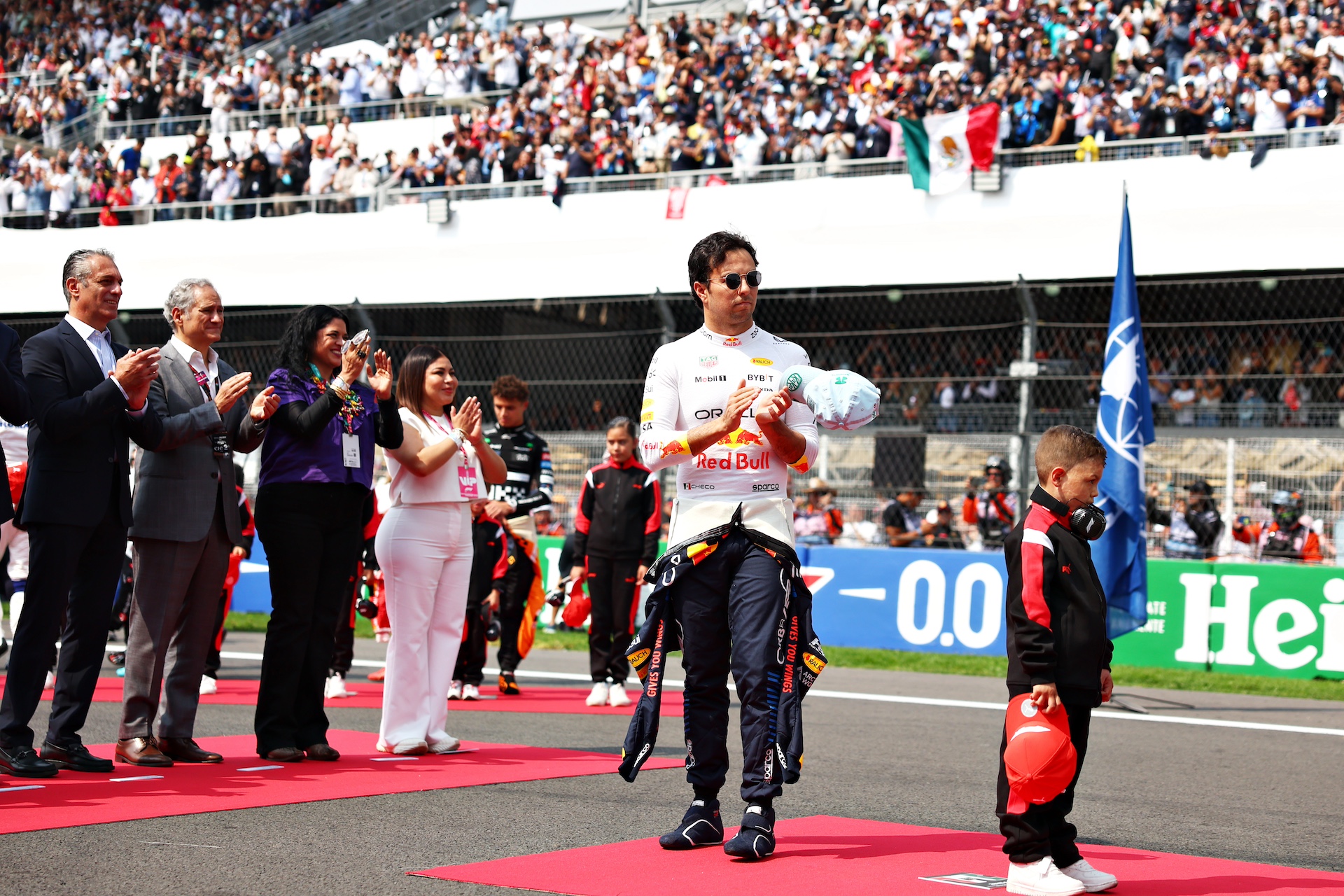 MEXICO CITY, MEXICO - OCTOBER 27: Sergio Perez of Mexico and Oracle Red Bull Racing acknowledges the fans in the stands on the grid prior to the F1 Grand Prix of Mexico at Autodromo Hermanos Rodriguez on October 27, 2024 in Mexico City, Mexico. (Photo by Bryn Lennon - Formula 1/Formula 1 via Getty Images)