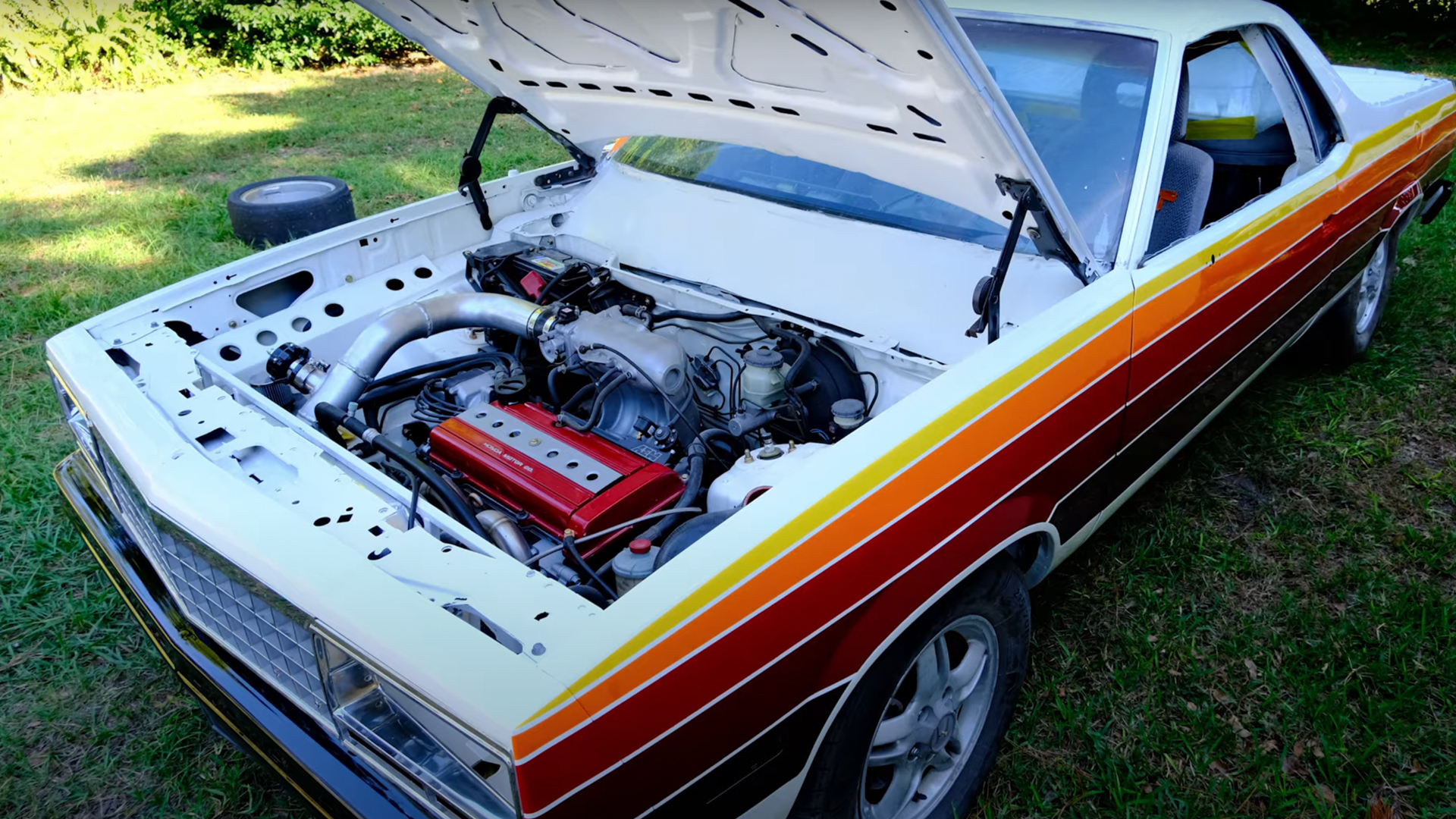 An El Camino built on a Honda CR-V platform and powertrain, with the hood open showing off the engine.