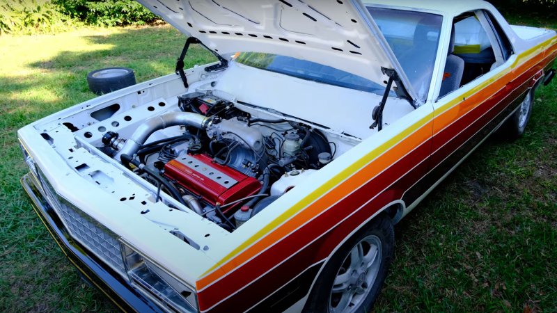 An El Camino built on a Honda CR-V platform and powertrain, with the hood open showing off the engine.