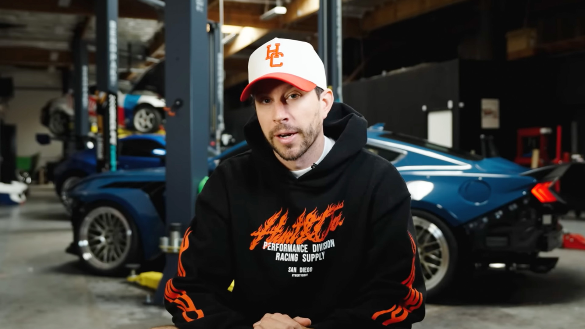 TJ Hunt speaks in a YouTube video in front of his Ford Mustang project car.