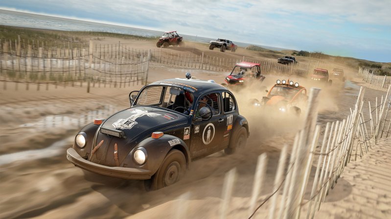 A VW Beetle races other cars on a sandy beach in Forza Horizon 4.