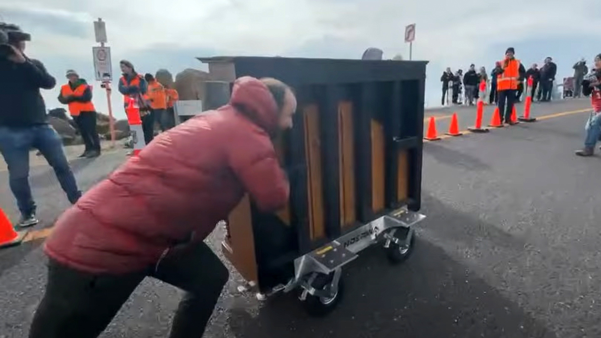 Kelvin Smith pushes piano up mountain hill climb in Australia.