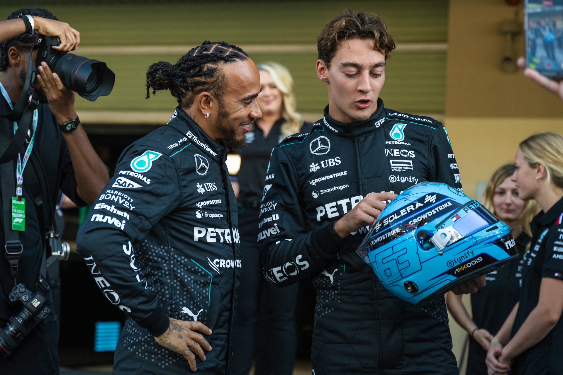 Mercedes' British driver Lewis Hamilton (L) listens to Mercedes' British driver George Russell after posing for a group photo with his team ahead of the Abu Dhabi Formula One Grand Prix at the Yas Marina Circuit in Abu Dhabi on December 5, 2024. (Photo by Andrej ISAKOVIC / AFP)