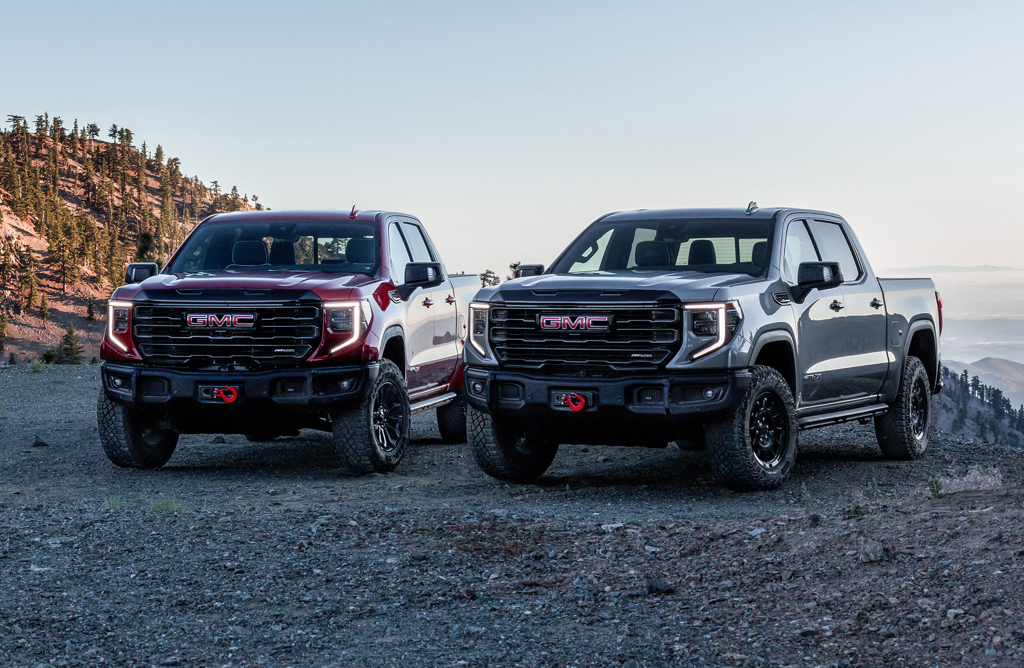 Front three-quarter views of the 2023 GMC Sierra 1500 AT4X AEV Edition (right) and the new 2023 GMC Sierra 1500 AT4X (left) parked off-road. Later in the 2023 model year, a new Sierra 1500 AT4X will be available with AEV-inspired enhancements, including a stamped steel winch-capable front bumper, boron steel front approach skid plate and 33-inch Goodyear Wrangler Territory MT tires.