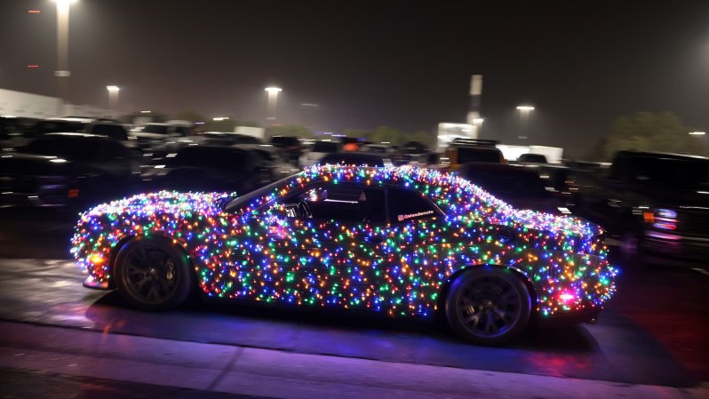 Irwindale, California December 5, 2024-A car with Christmas lights drives through the parking lot on the final Thursday Night Thunder at Irwindale Speedway. (Wally Skalij/Los Angeles Times via Getty Images)